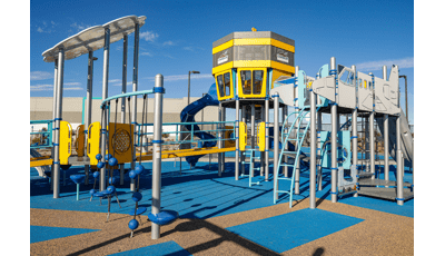 Play structure made of ramps, climbers and slides designed like an airport control tower and jet airplane.
