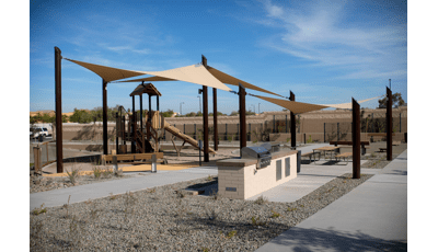 Nature-inspired PlayBooster play structure covered by custom SkyWays shade sails.
