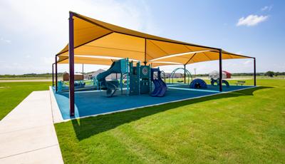 A PlayBooster playground packed with plenty of freestanding play activities as well as inclusive one such as Rhapsody® outdoor musical instruments, OmniSpin® spinner, and Cozy Dome®. All covered by SkyWays® commercial shade sails.