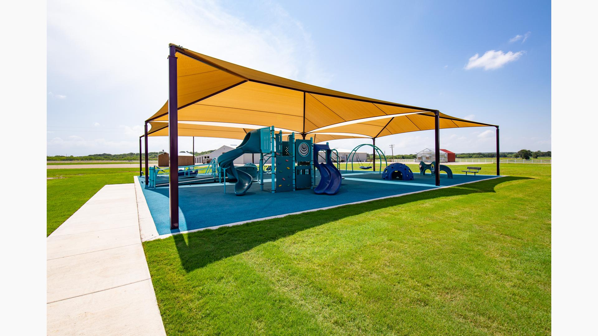 A PlayBooster playground packed with plenty of freestanding play activities as well as inclusive one such as Rhapsody® outdoor musical instruments, OmniSpin® spinner, and Cozy Dome®. All covered by SkyWays® commercial shade sails.