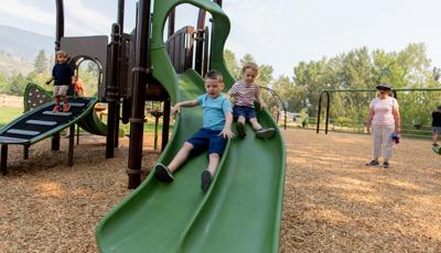 Two boys riding down slide