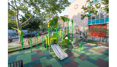 Children run on ramp as boy rides down slide.