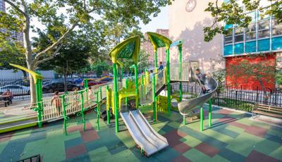 Children run on ramp as boy rides down slide.