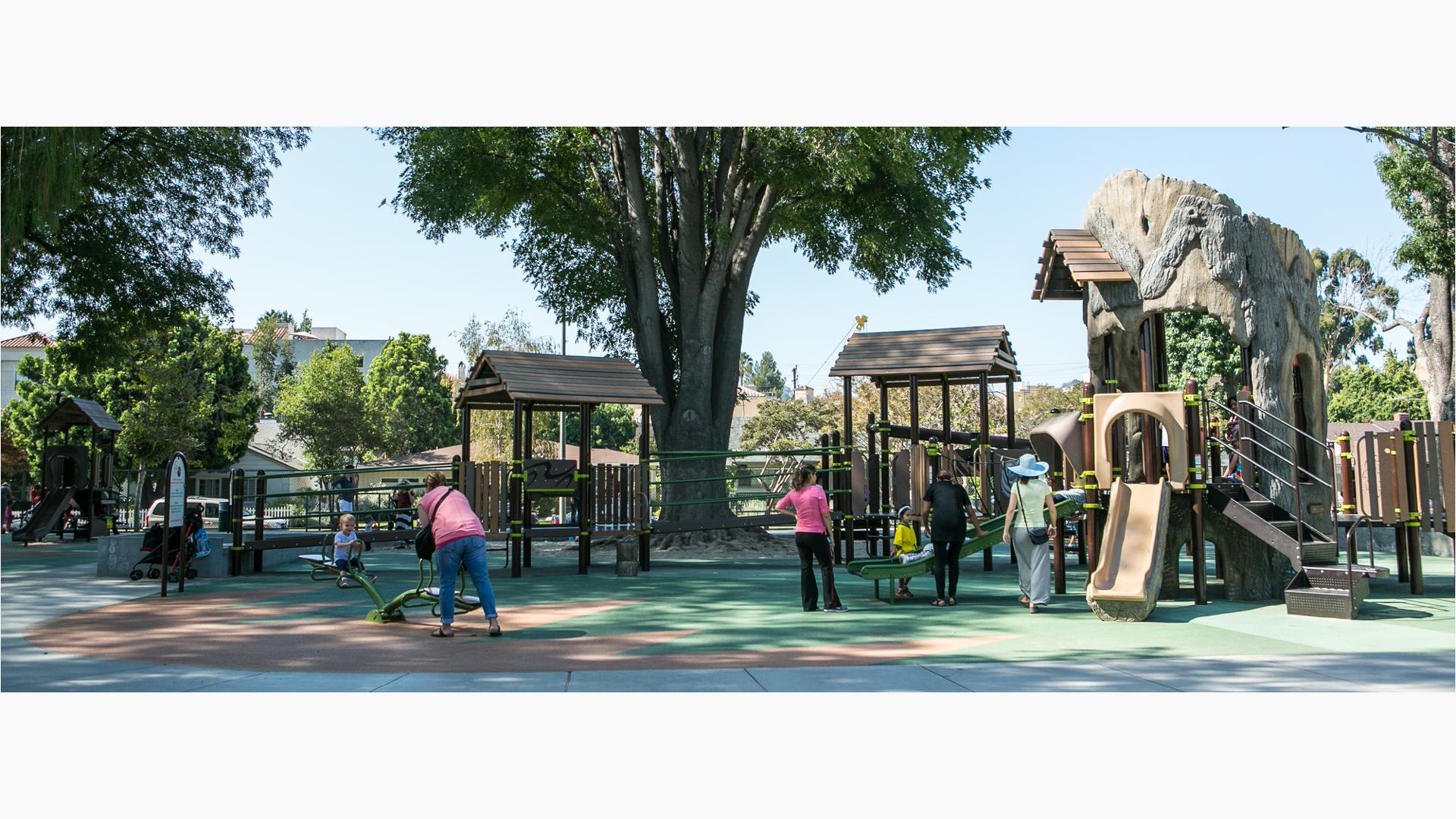 Parents play with their kids at this naturally-themed playground