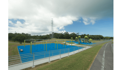 A large open play space has multiple bays of swings and a large play structure to the right.