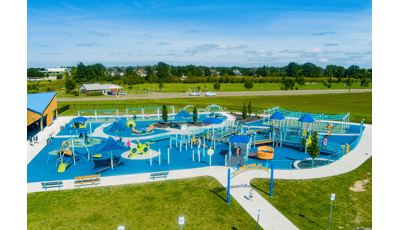 Elevated view of a large inclusive playground filled with playing families.