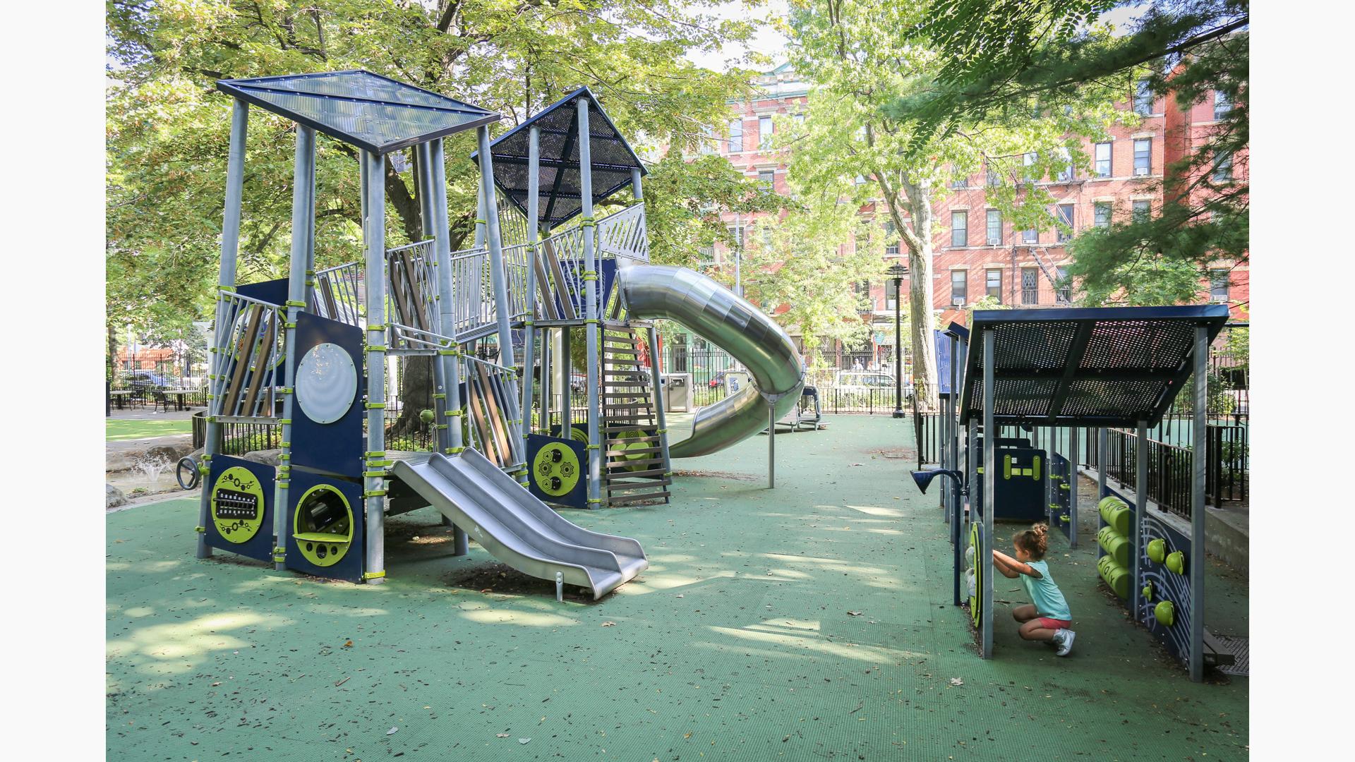 Child plays on learning wall next to Joseph C. Sauer Park playscape