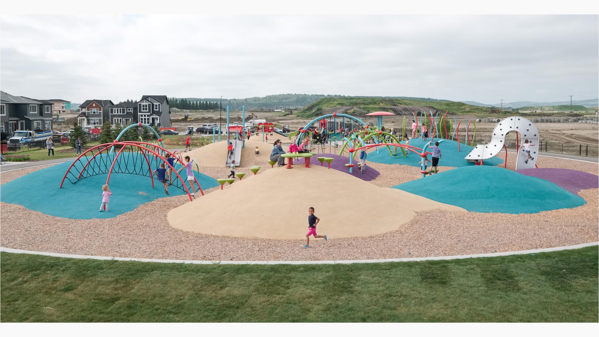 Children play on the uniquely arched and colored climbers of a neighborhood park.