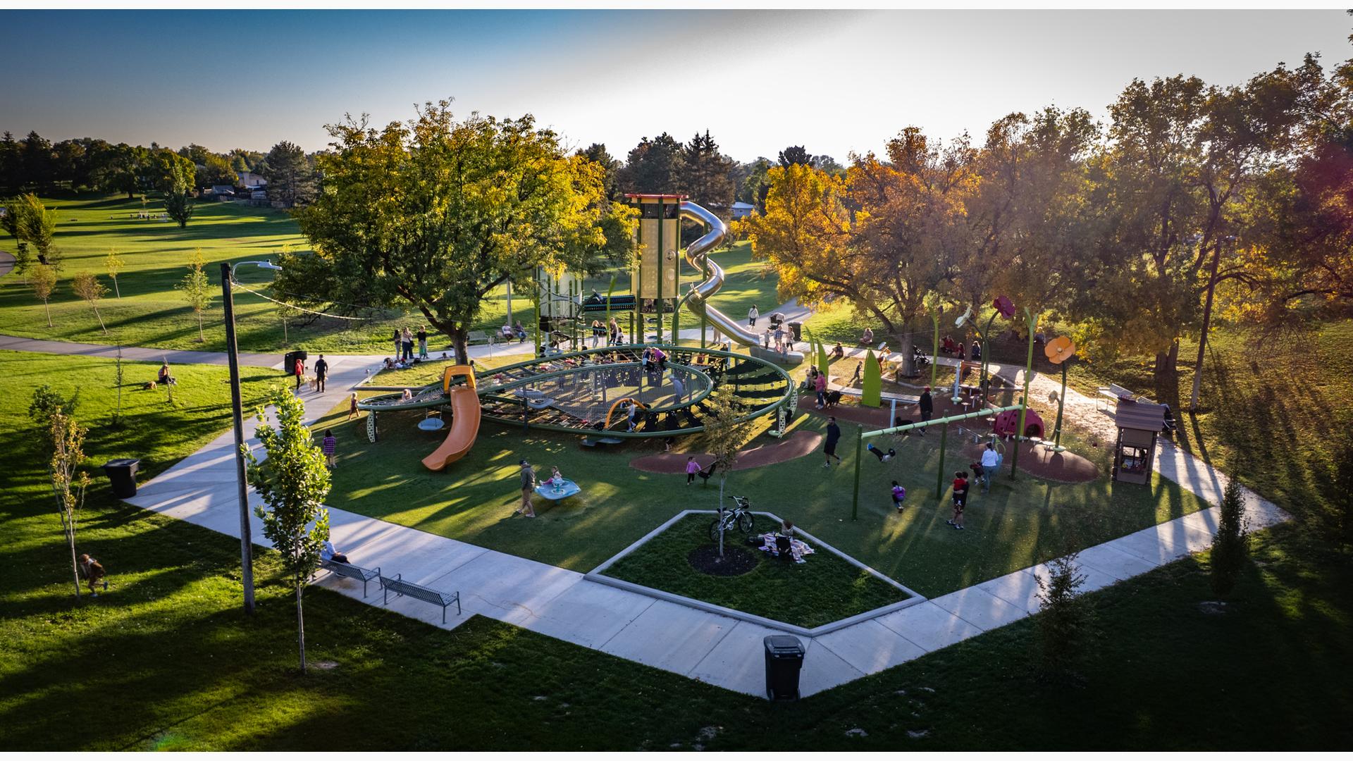 Elevated view of a hexagonal shaped playground play area with a large main tower with stainless steel slide and a secondary large figure eight shaped climbing structure.