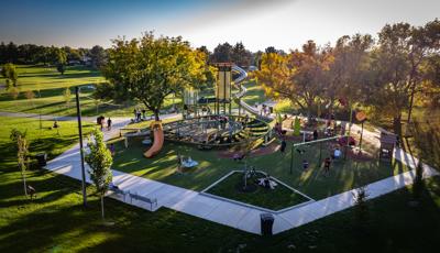 Elevated view of a hexagonal shaped playground play area with a large main tower with stainless steel slide and a secondary large figure eight shaped climbing structure.