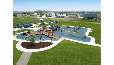 Elevated view of a neighborhood park inclusive play area. The playground is connected by accessible ramps and bridges surrounded by a swing set, zip line, and manual carousel. 