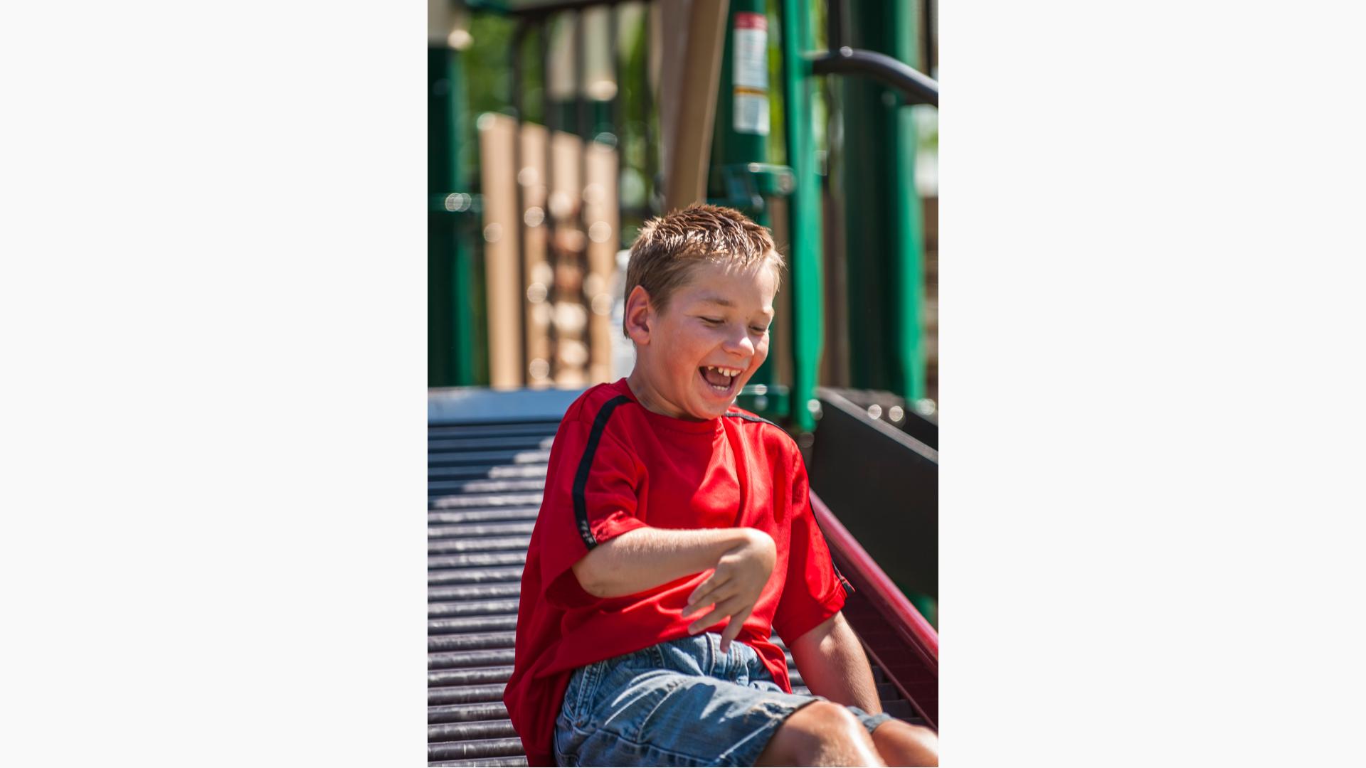 Boy in red shirt sitting on rollerchair