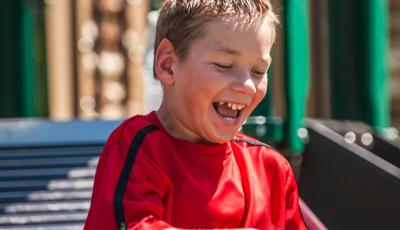 Boy in red shirt sitting on rollerchair