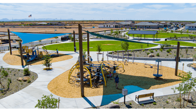 Elevated view of two separate play areas divided by walking paths under large triangular blue shade sails.