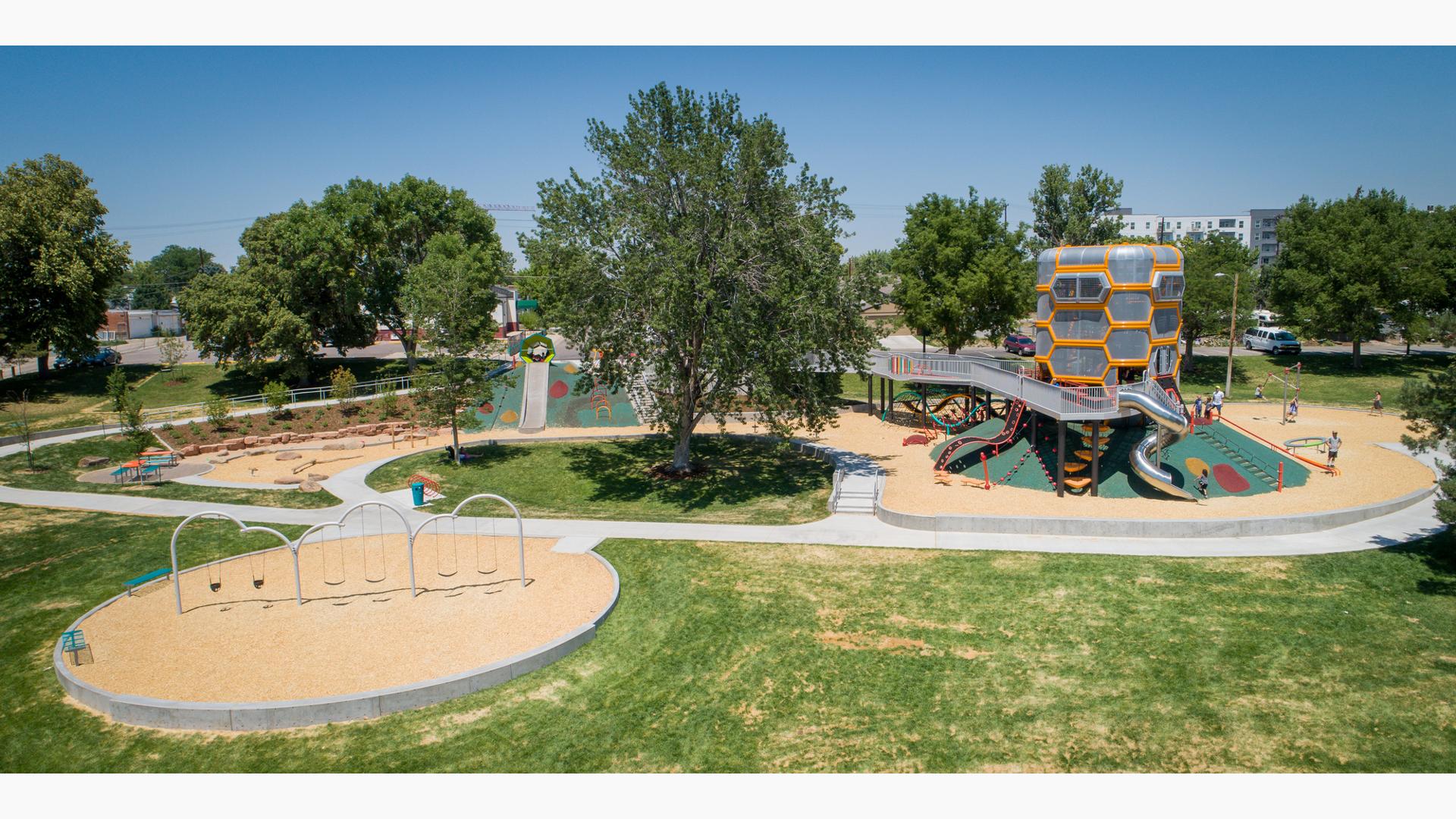 The sun shines down on Paco Sanchez Park
in Denver, CO as kids play inside the giant vintage vocal mic -inspired tower.