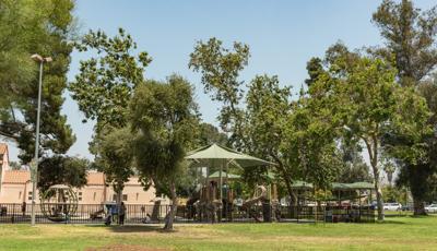 Large trees give a natural canopy to the Sun Valley Rec Center playground. The playground features rock climbers, a double ZipKrooz, and Skyways shade panels in addition to the natural tree shade.