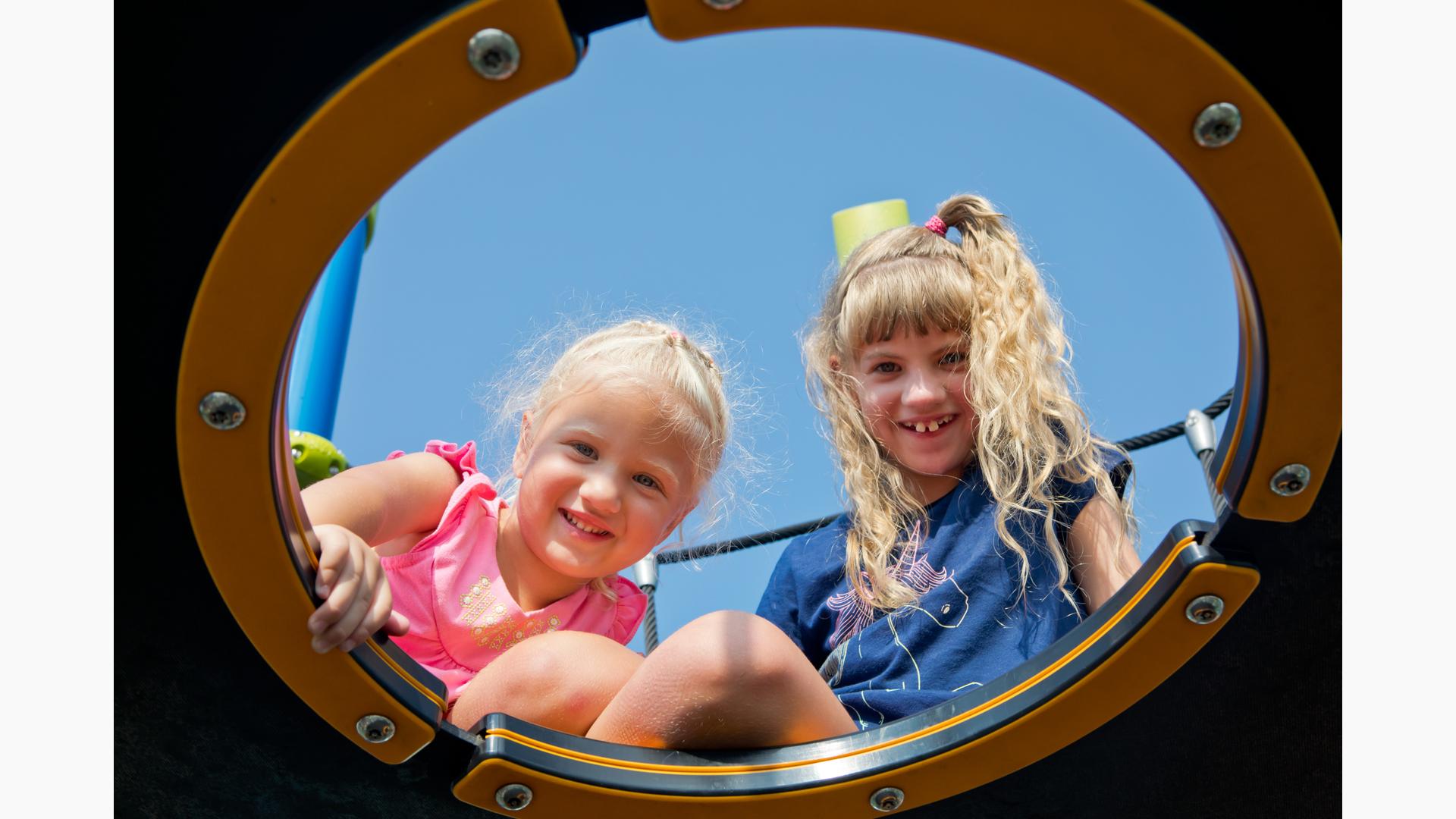 Two girls smiling on Netplex® play structure