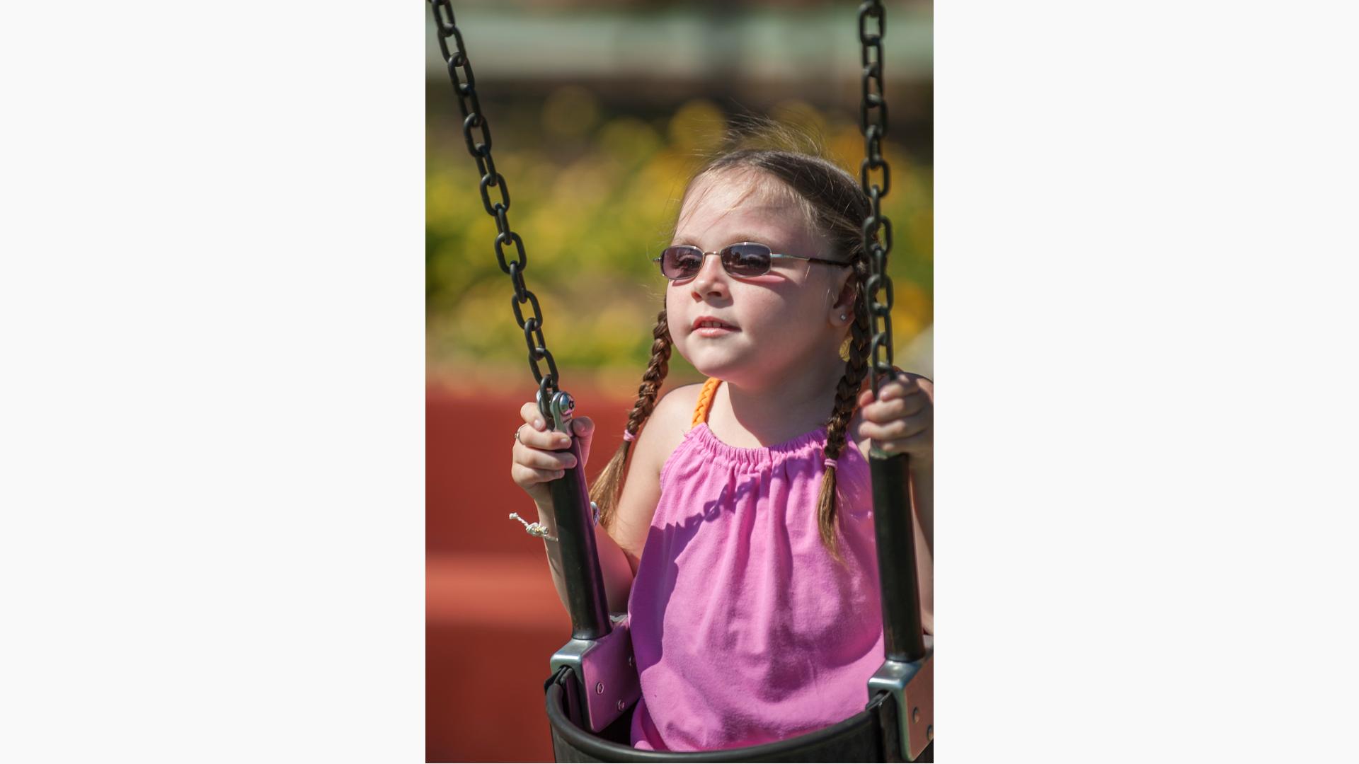 LIttle girl in bucket swing