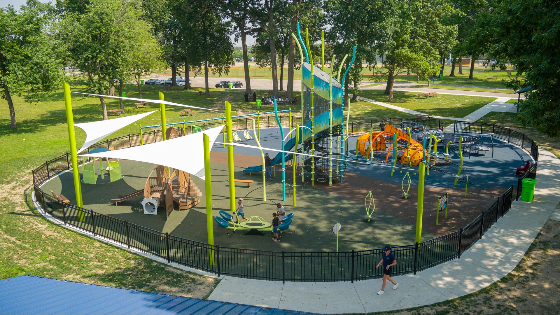 Elevated view of a nature themed playground with structures shaped like a rabbit, fish, and dragonfly.