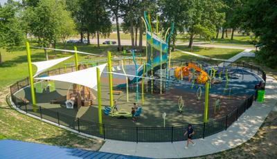 Elevated view of a nature themed playground with structures shaped like a rabbit, fish, and dragonfly.