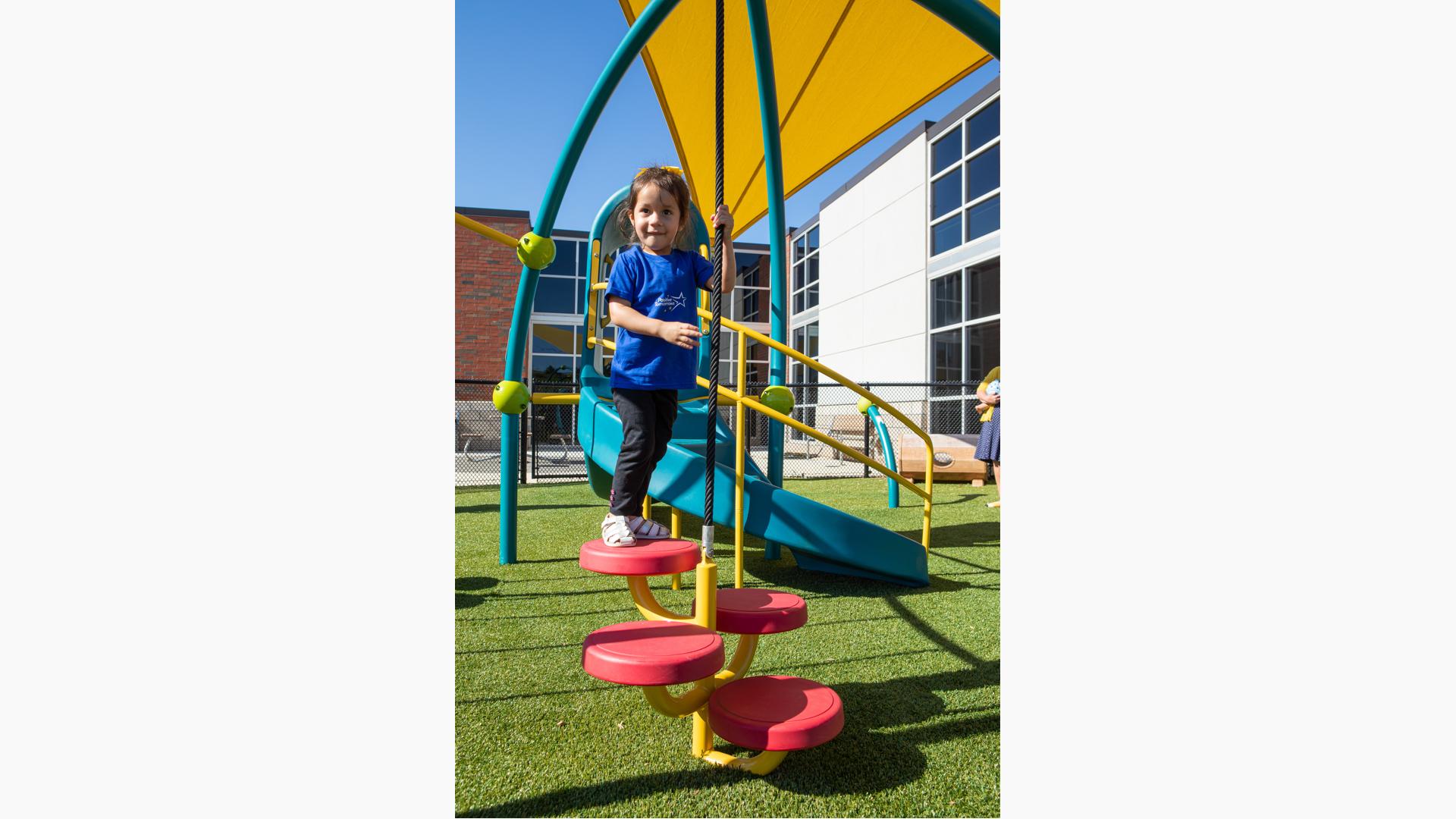 GIrl in black pants standing on Wee Pod® Climber