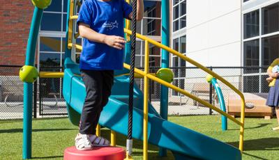 GIrl in black pants standing on Wee Pod® Climber