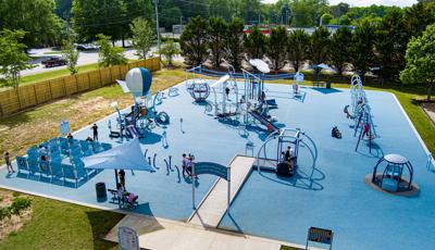 Elevated view of a large inclusive playground with blue safety surfacing. 