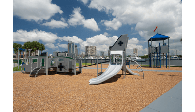 Custom playground themed like a jet with a look out tower located near a lake. 