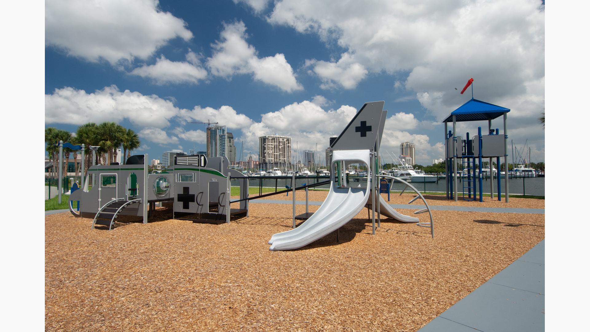 Custom playground themed like a jet with a look out tower located near a lake. 