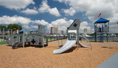 Custom playground themed like a jet with a look out tower located near a lake. 