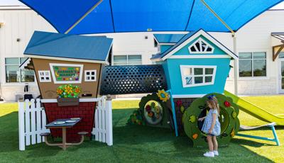 Two small house shaped structures with play panels are connected by a perforated crawl tunnel.