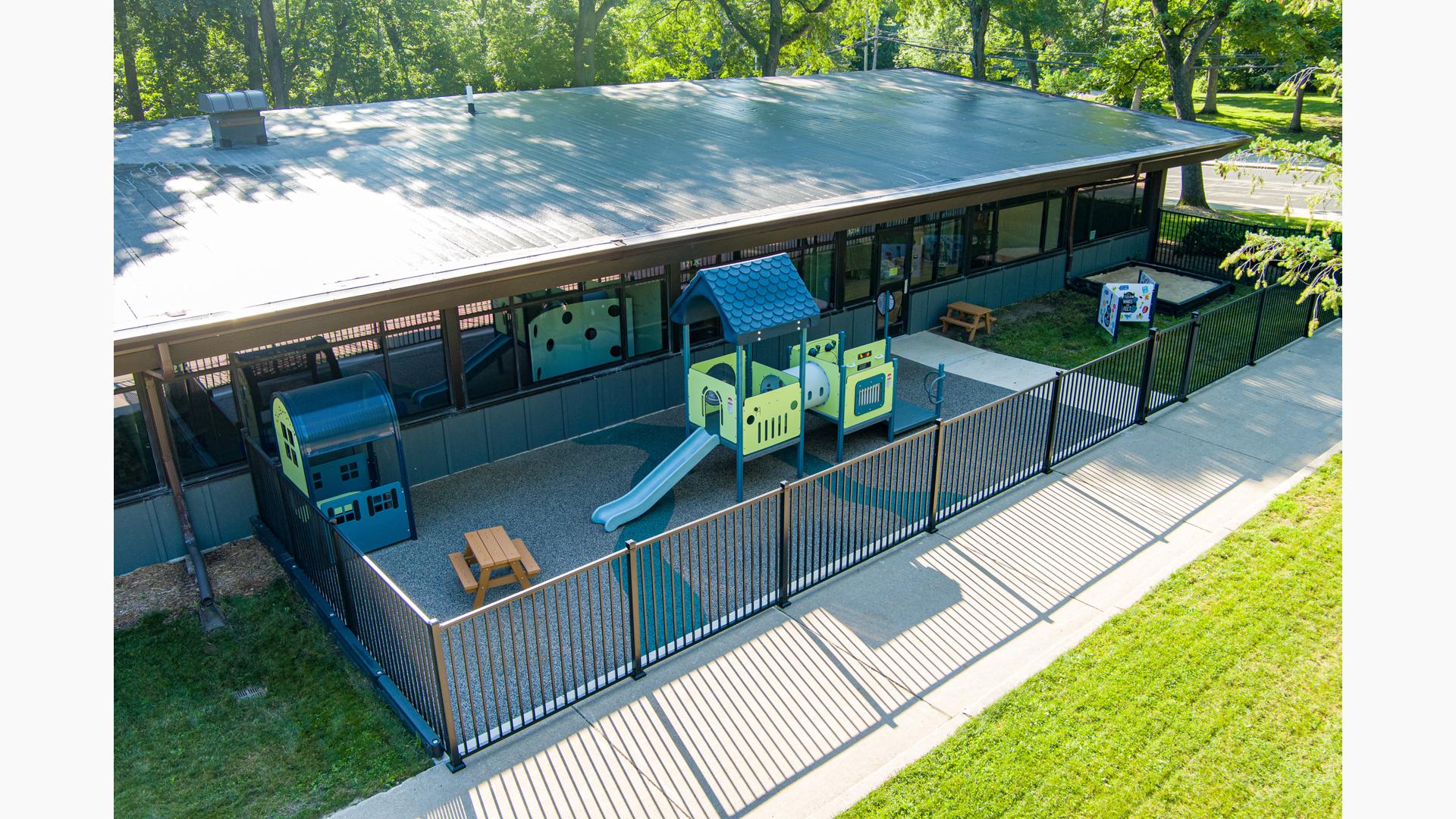 Elevated view of an outdoor enclosed daycare play area.