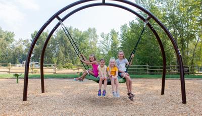 Girls sitting and smiling on Oodle® Swing