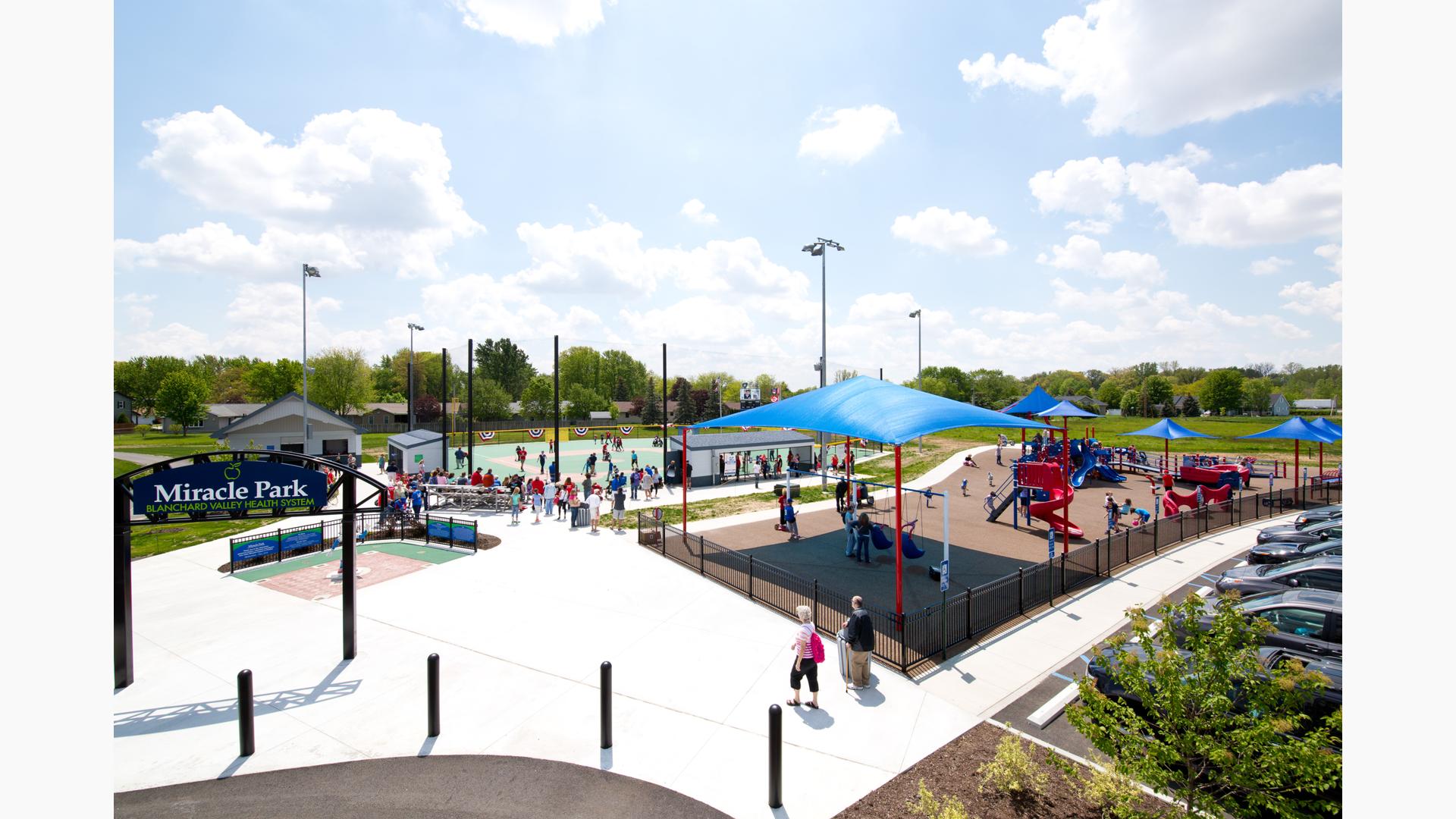 A Baseball game goes on while children play at Blanchard Valley Health System Miracle Park.