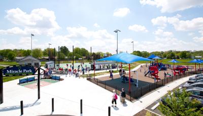 A Baseball game goes on while children play at Blanchard Valley Health System Miracle Park.