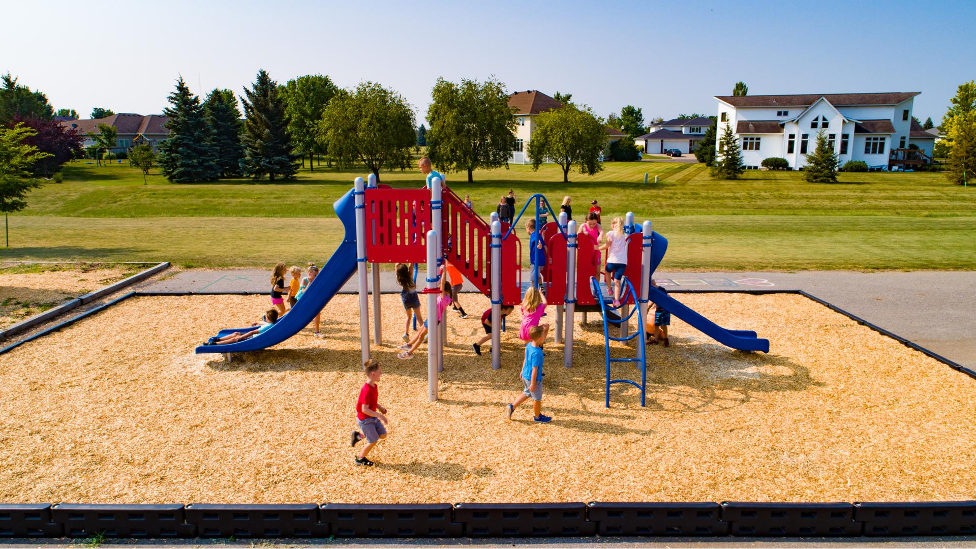 A big group of children playing on a compact playground with lots of climbers and slides