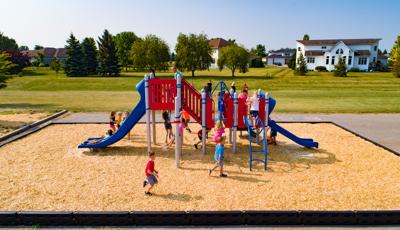 A big group of children playing on a compact playground with lots of climbers and slides