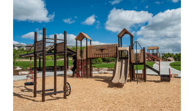 Cattle ranch themed PlayBooster playscape with tire swing and dud ranch style signage.