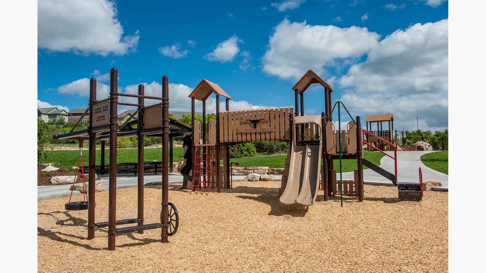 Cattle ranch themed PlayBooster playscape with tire swing and dud ranch style signage.