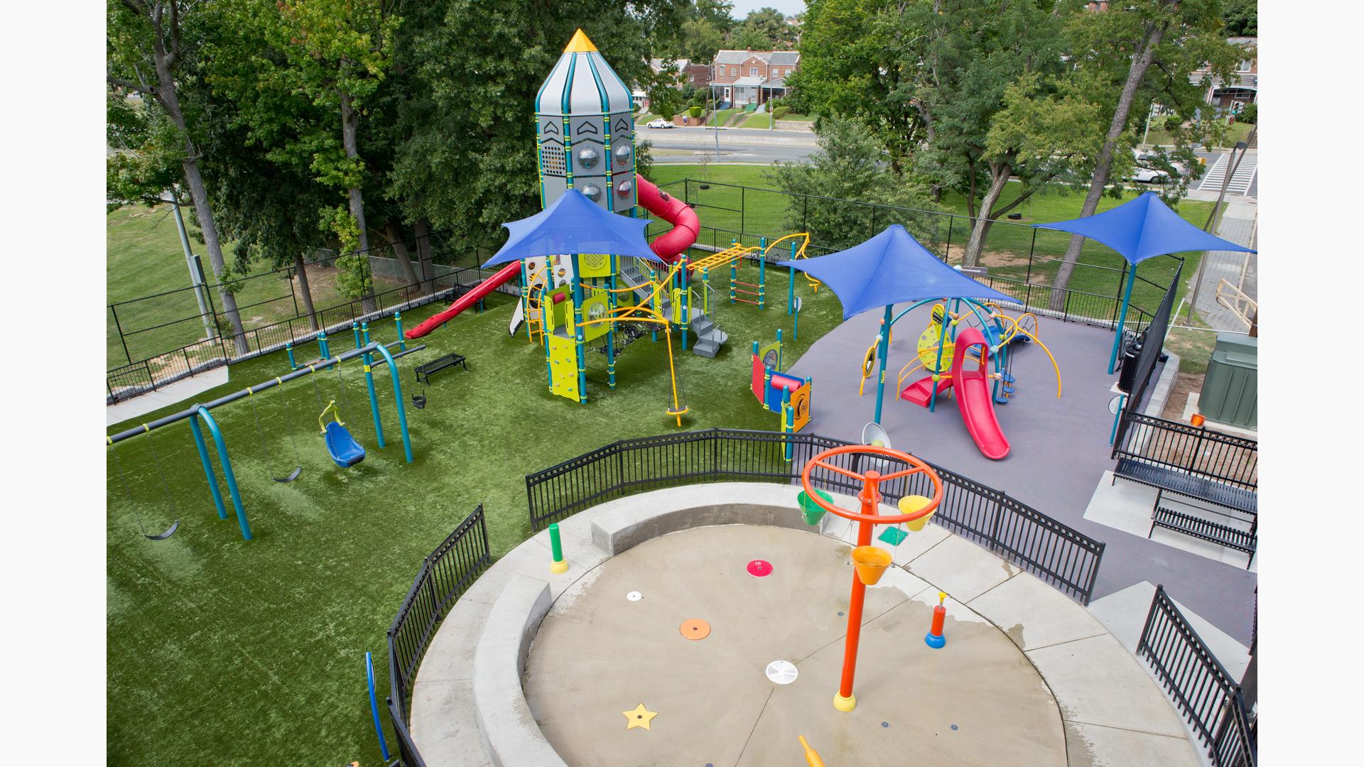 Aerial view of a park playground with a spaceship themed play tower.