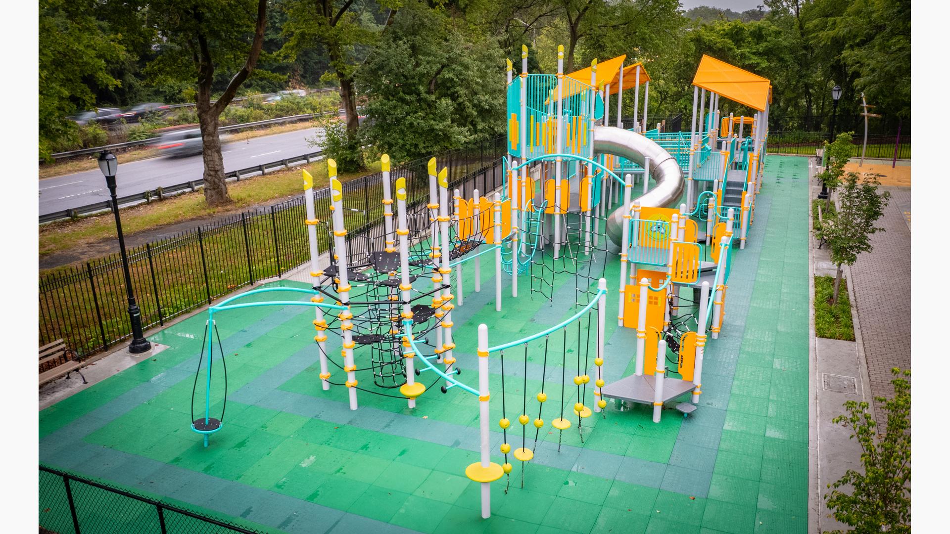 Elevated view of a park playground with bright aqua and yellow accents.
