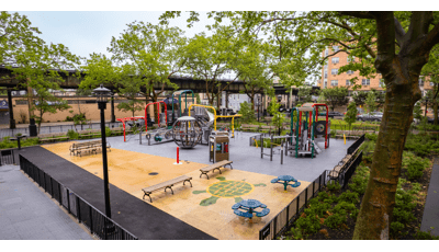 A brightly colored park playground amongst city buildings.