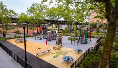 A brightly colored park playground amongst city buildings.