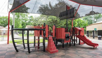 Custom pirate ship designed playground sitting under black skull with cross swords shade canopy.