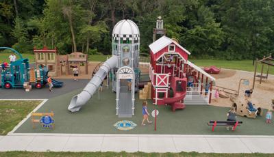 Custom farm-themed PlayBooster playground has two towers and a pickup truck-shaped slide for kids to ride down or climb on.