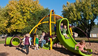 Toddlers swarm over the Weevos play system in St. Joseph's Youth Center. A long line of children forms for the slide.