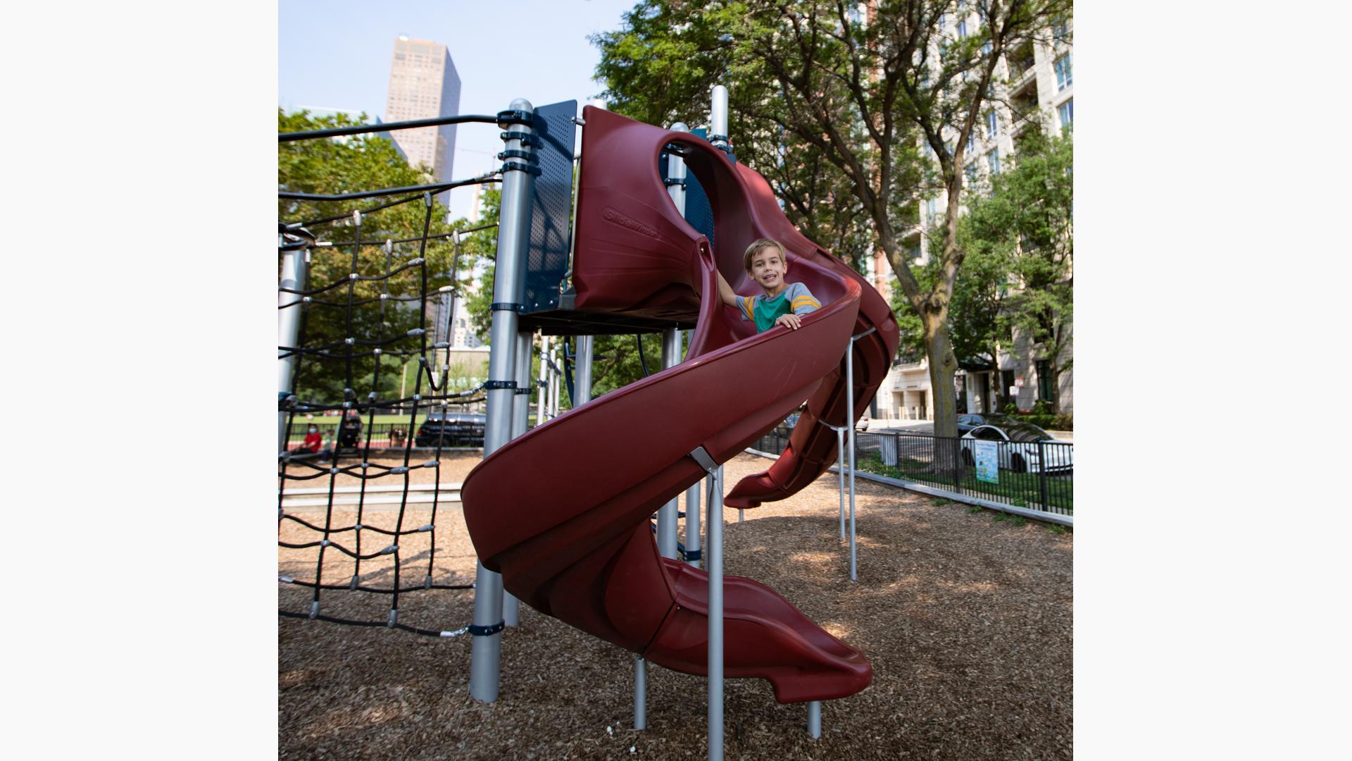 Boy riding down Play Booster slide