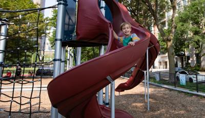 Boy riding down Play Booster slide