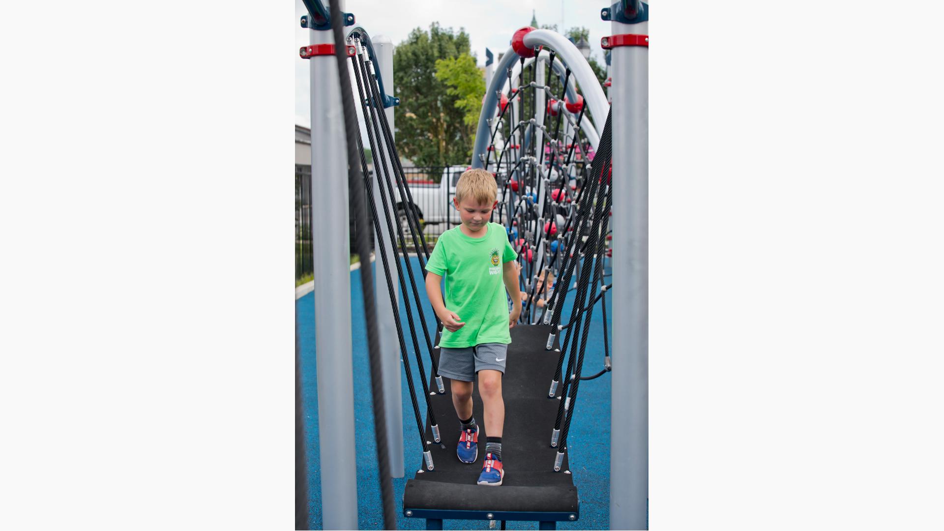 Boy walking across bridge