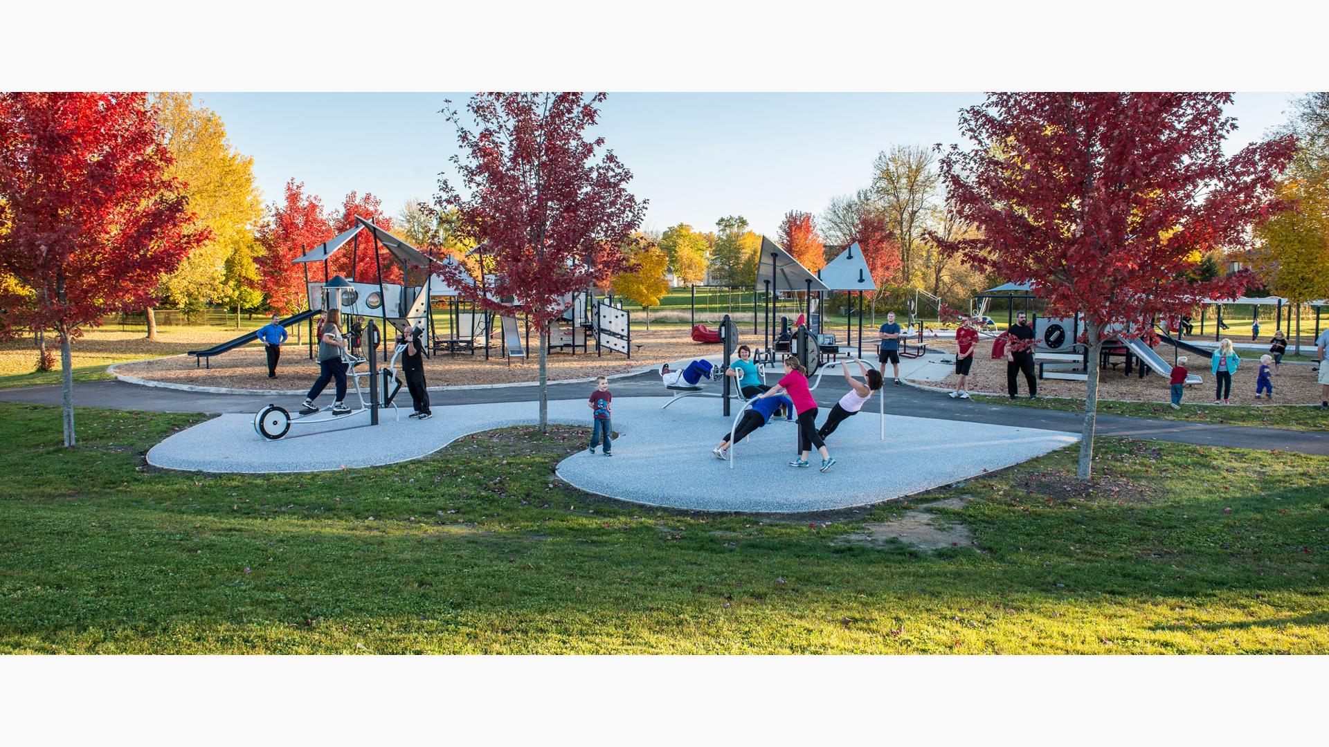 One part fitness. One part playground.  All fun. While adults use the exercise equipment, children in the background play on the custom PlayBooster play system at Barb King Inspiration Park. A custom  one-of-a-kind park built in honor of Play LSI cofounder Barbara King.